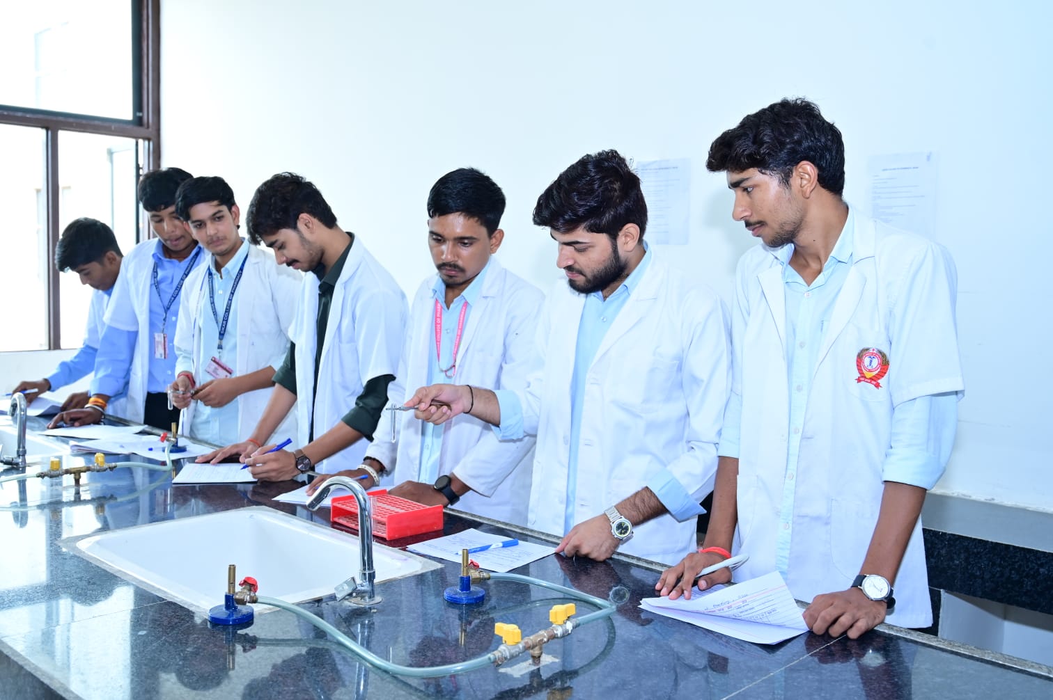 Students completing practical records at an MGGC Sikar laboratory bench