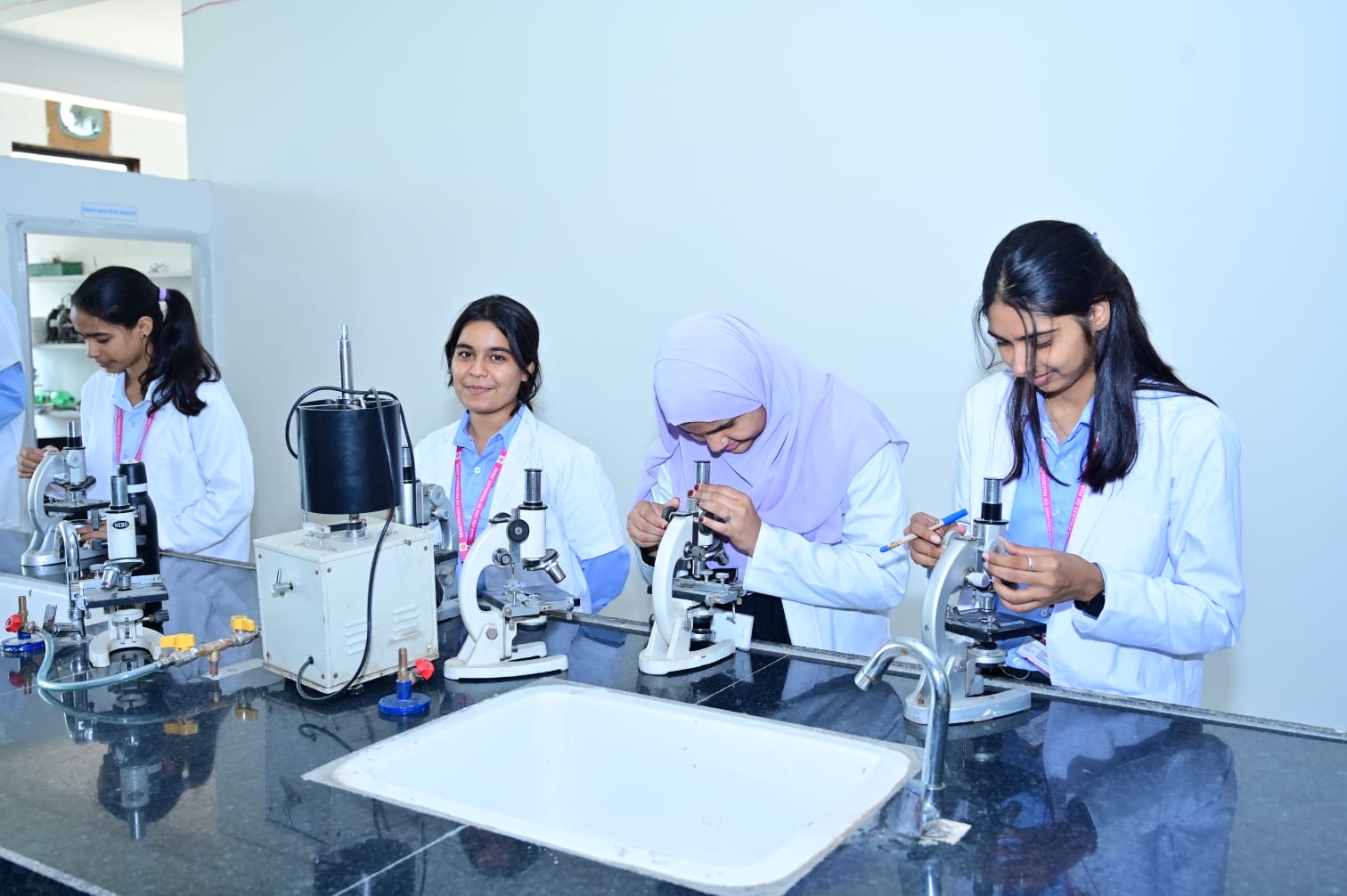 Students working with microscopes in an MGGC Sikar laboratory