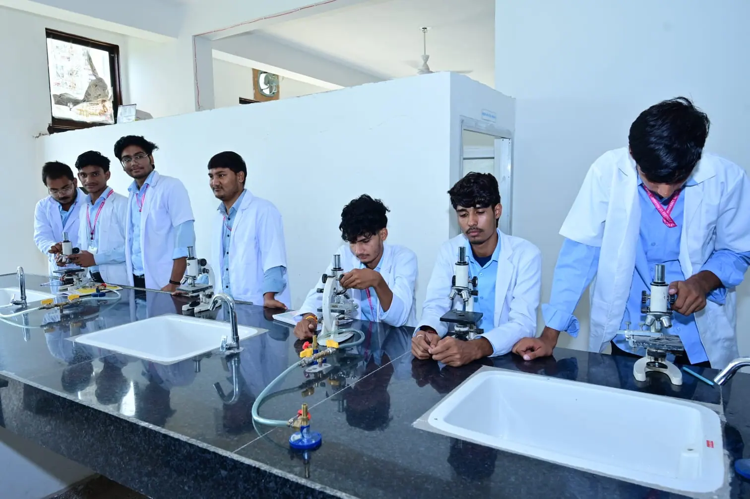 Student group using microscopes at an MGGC Sikar laboratory bench