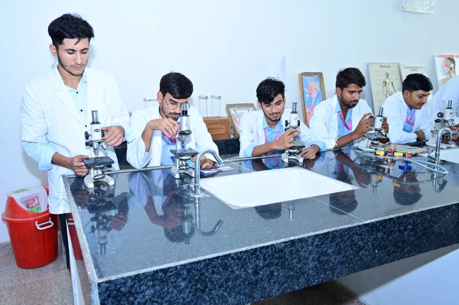 Students completing microscope-based practical work at MGGC Sikar