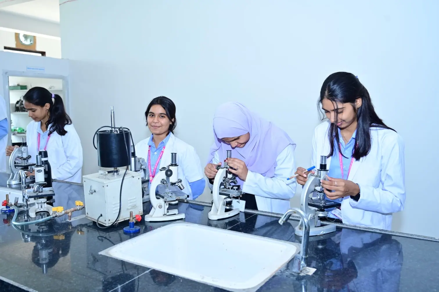 Students working with microscopes in an MGGC Sikar laboratory