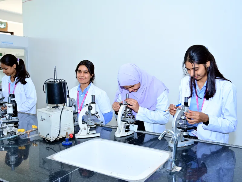 Students working with microscopes in an MGGC Sikar laboratory